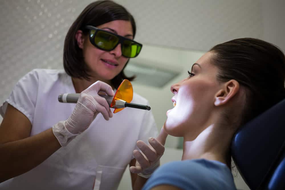 dentista examina dientes pacientes luz curado dental